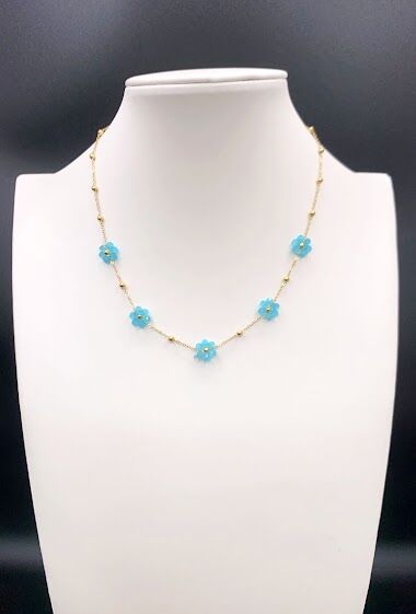 Un collier bijoux avec des perles turquoise sur un mannequin en acier inoxydable.