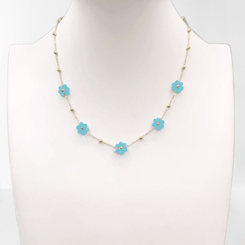 Un mannequin portant un collier de fleurs bleues en acier inoxydable.