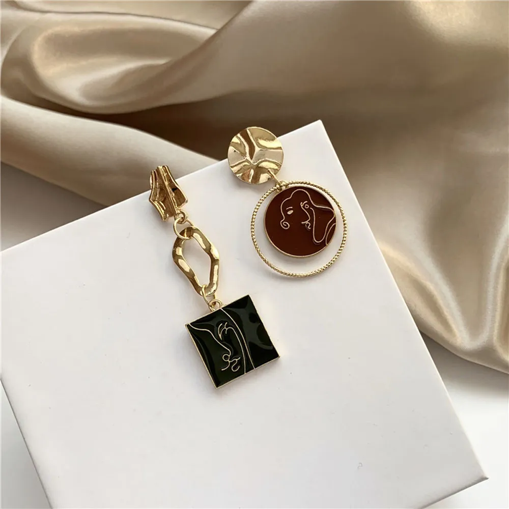 Une paire de boucle d'oreille femme asymétrique pendentif abstrait avec un design noir et vert.