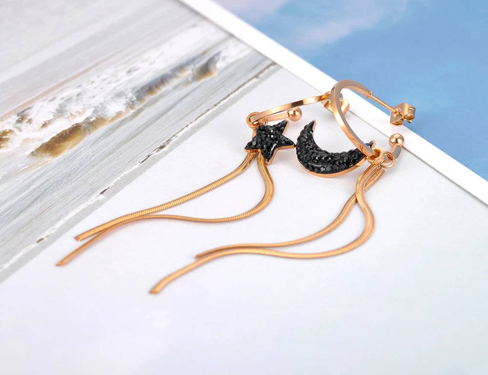 Une paire de Boucle d'oreille asymétrique lune étoile avec un motif étoile et lune.