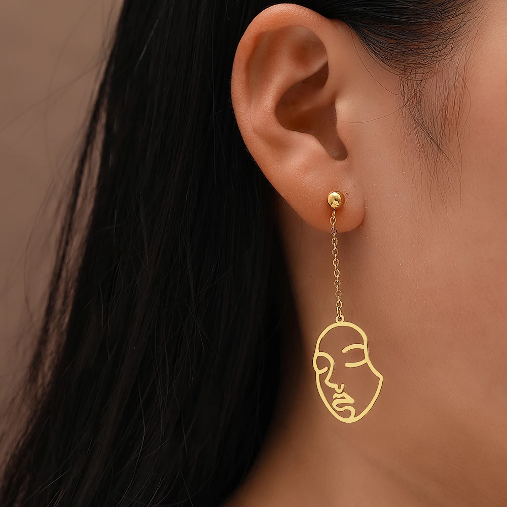 Une femme portant une boucle d'oreille visage dépareillée.