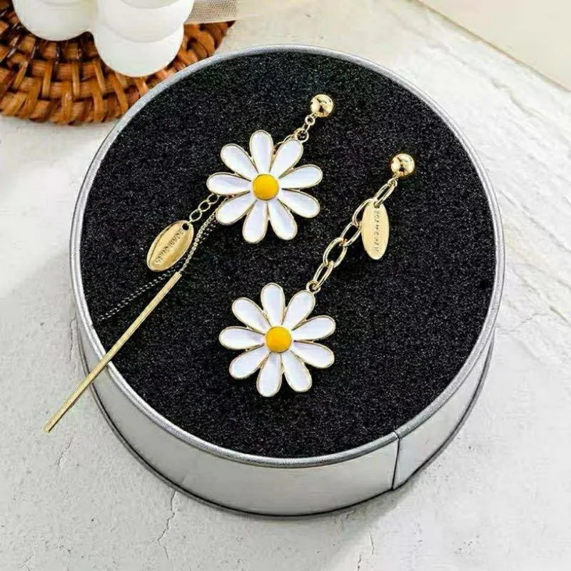 Daisy Boucle d'Oreille Fleur Asymétrique dans une boîte en fer blanc.