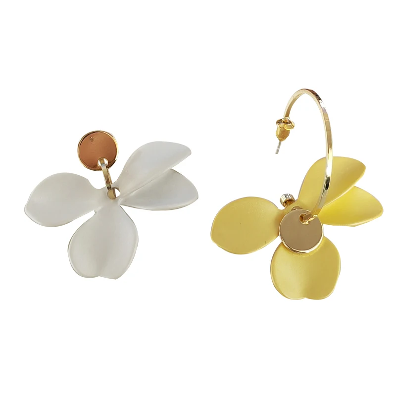 Une paire de boucles d'oreilles à fleurs jaunes et blanches.