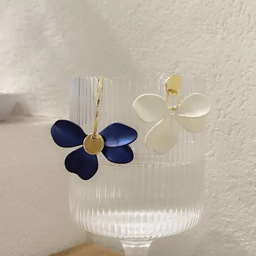 Un verre avec une paire de Boucles d'oreilles asymétriques Pétales de Fleurs.