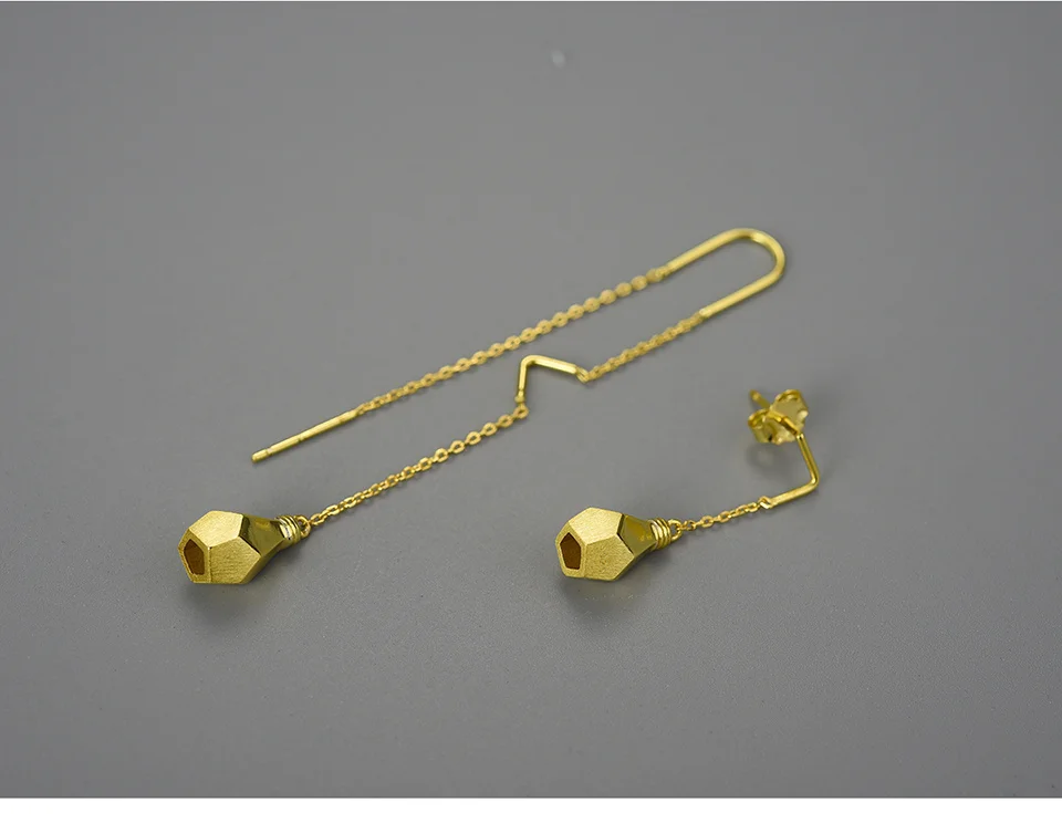 ROSY Boucles d'oreilles asymétriques doré goute sur un fond gris